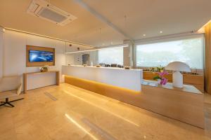 a lobby with a counter and a desk and some windows at Hotel Maritim in Roses