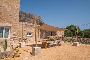 a patio with a table and chairs in front of a building at Masseria Il Passo in Favignana