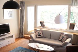 sala de estar con sofá y ventana grande en fewo1846 - EastSide - komfortables Apartment im 2 OG mit Balkon und TG-Stellplatz en Flensburg