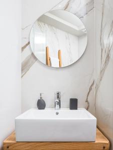a bathroom with a white sink and a mirror at The H Experience Boutique Apartment Downtown Heraklion in Heraklio