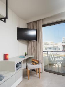 a living room with a desk and a balcony at The H Experience Boutique Apartment Downtown Heraklion in Heraklio