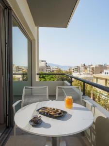 a white table with a tray of cookies on a balcony at The H Experience Boutique Apartment Downtown Heraklion in Heraklio