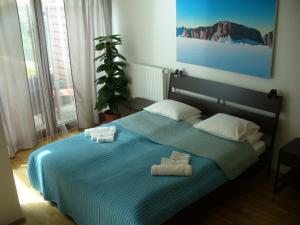 a bedroom with a blue bed with two towels on it at Garden apartment with garage in central Prague in Prague