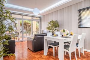 a dining room with a white table and chairs at Canico Sea Garden by Madeira Sun Travel in Caniço