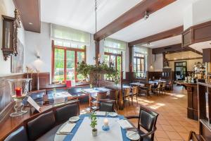 a restaurant with tables and chairs and windows at Landhotel Rittmeister & Kräuter-SPA Adults Only in Rostock