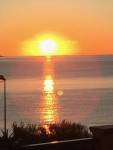 a sunset over the ocean with the sun setting at Sunrise B&B Le castella in Le Castella