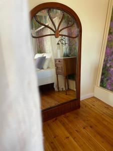 a mirror in a room with a bed and a table at REFUGIUM Theresienstraße 19 - Chambre Monet in Rhodt unter Rietburg