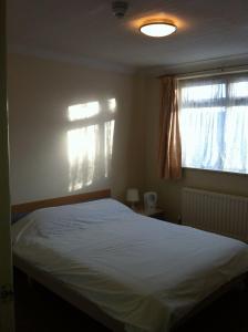 Un dormitorio con una cama grande y una ventana en Hillingdon Lodge, en Hillingdon