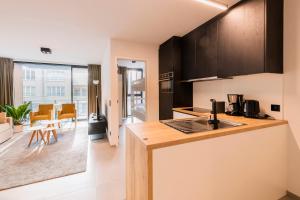 a kitchen with black cabinets and a counter top at Belcasa Beach Suites & Lofts Aparthotel in Middelkerke