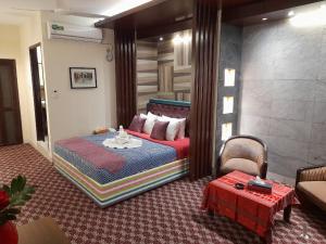 Center Point Apartment في داكا: غرفة نوم فيها سرير وطاولة فيها