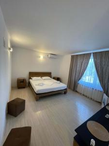 a bedroom with a bed and a large window at VILA REGAL Mamaia in Mamaia