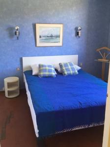 a blue bedroom with a bed with blue sheets and pillows at 5VSE-LAM56 Appartement avec vue sur la baie in Collioure