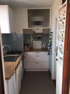 a small kitchen with white cabinets and a sink at 5VSE-LAM56 Appartement avec vue sur la baie in Collioure