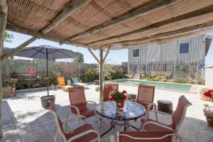 eine Terrasse mit einem Tisch, Stühlen und einem Pool in der Unterkunft Casa Encarnacion in Granada