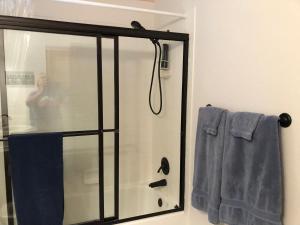 um chuveiro com uma porta de vidro na casa de banho em 1 or 2 bedrooms with bath in our shared home at Indian Peaks Golf Course em Lafayette