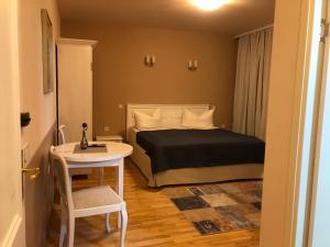 a bedroom with a bed and a white table and chair at Vila David in Baile Unu Mai