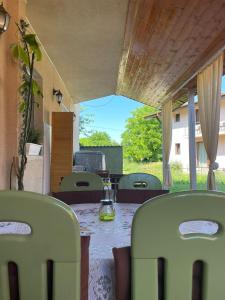 a table with green chairs and a glass jar on it at Vila David in Baile Unu Mai +2 photos
