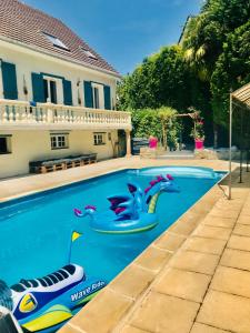 a swimming pool with a water slide in a house at Appartement 120m2 dans maison avec piscine in Boissy-lʼAillerie