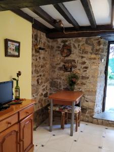 a dining room with a table and a stone wall at Apartamentos Casa Margot in Sevares