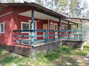 a red house with a large porch on the side of it at Takalahti Lodge in Puumala
