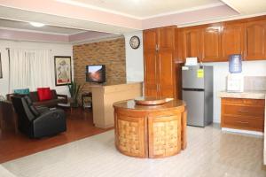 a kitchen and living room with a table and a refrigerator at Comfy Dwelling in Baguio