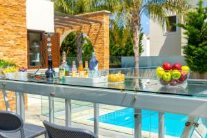 einen Tisch mit Obst und Getränken auf dem Pool in der Unterkunft Ayia Napa Ionion Seaside Villa in Ayia Napa + 61 Fotos