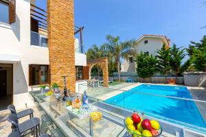 eine Villa mit Swimmingpool und ein Haus in der Unterkunft Ayia Napa Ionion Seaside Villa in Ayia Napa