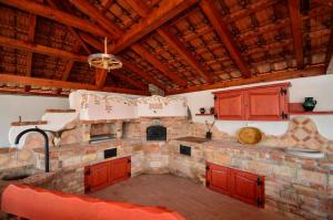 cocina grande con pared de piedra y techo de madera en Hanság Vendégház, en Kapuvár