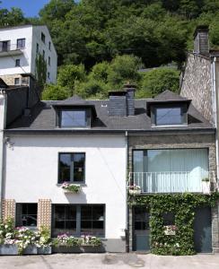 ブイヨンにあるAu 13 Faubourg de France, 160m carrés à 50m de la Semois et 200m de l'animation du centre villeの窓とバルコニー付きの白い家