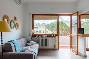 a living room with a couch and a large window at JOIVY Apartment Apollo in Rapallo