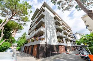 an apartment building on a street with cars parked in front at JOIVY Apartment Apollo in Rapallo