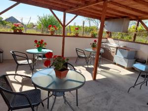 a patio with tables and chairs and a kitchen at Casa Anhela in Corbu