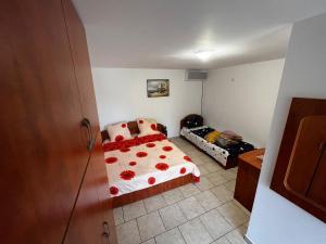 a bedroom with a bed with red flowers on it at Casa Anhela in Corbu