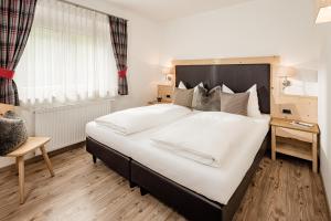 - une chambre avec un grand lit et une fenêtre dans l'établissement Apartment Bellaria, à Santa Cristina Valgardena
