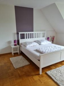 a bedroom with a white bed and two rugs at Unterkunft in Erholungsort Sterup Nähe von Ostsee in Sterup