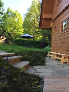 un patio con sombrilla junto a una casa en Chatka z sauną nad rzeką en Żabnica