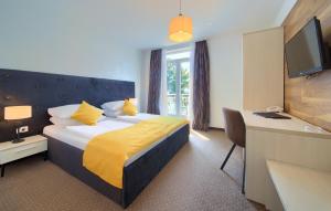 a hotel room with a bed with a yellow blanket at Hotel Bor in Krk