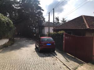 a red car parked in a driveway next to a fence at Apartamento Duda 03 in Monte Verde