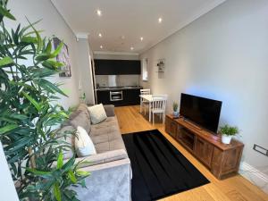 a living room with a couch and a flat screen tv at Lovely modern 1 bedroom apartment in Hendon