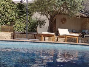 - une piscine avec 2 chaises, une table et un arbre dans l'établissement La Maison Des Autres, piscine chauffée, chambres d'hôtes proches Uzès, Nîmes, Pont du Gard, à Saint-Géniès-de-Malgoirès