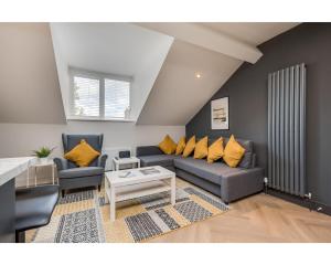 sala de estar con sofá azul y almohadas amarillas en Central Belfast Apartments: University Street, en Belfast