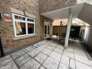 an outside patio with a table and a building at Lovely modern 1 bedroom apartment in Hendon