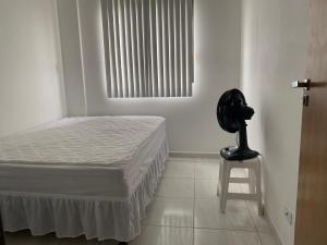 um quarto com uma cama, uma cadeira e uma janela em Apartamento 03B Residencial Morada do Vale em Garanhuns