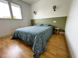 レ・サ​​ーブル・ドロンヌにあるLa Maison Cilaos - Proche merのベッドルーム1室(青い毛布、窓付)