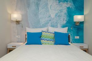 a bedroom with a bed with blue and white pillows at A.S.Apartamenty Bożena Bocian in Niechorze