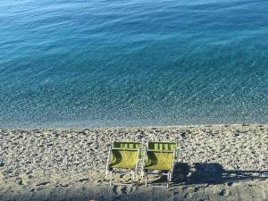 two chairs sitting on a beach next to the water at LE CINQUE VELE ***** Cinque Terre in Monterosso al Mare