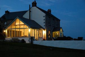 una casa iluminada por la noche con luces en Fig Tree House en Penryn