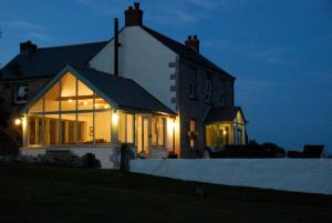 a house lit up at night with lights at Fig Tree House in Penryn