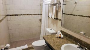 a bathroom with a toilet, sink, and bathtub at Combate Beach Resort in Cabo Rojo