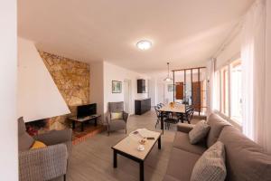 a living room with a couch and a fireplace at Bravissimo Vil·les Brusi D S'Agaró in S'Agaro